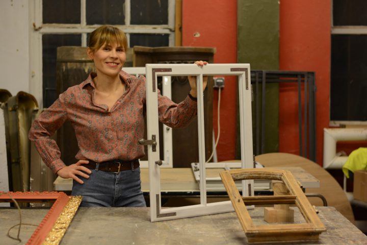 Katarzyna Płażyńska podczas warsztatów, trzymająca framugę okna.